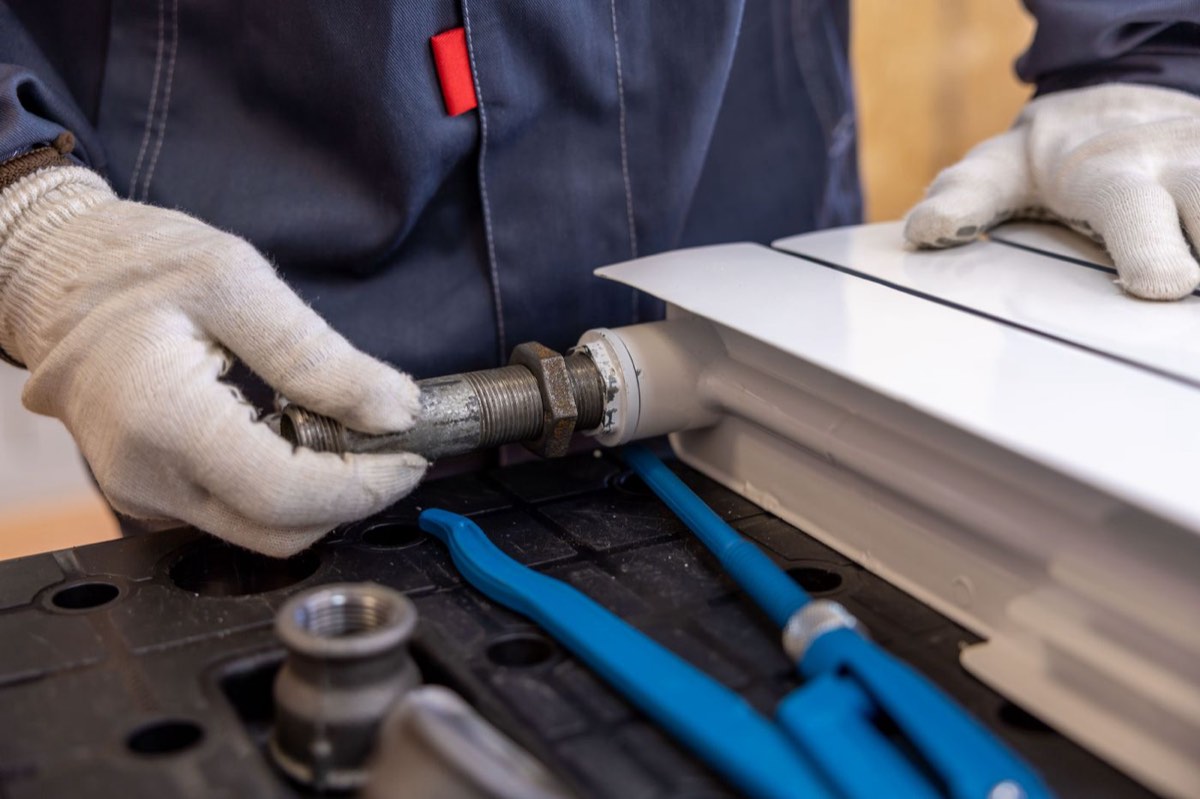 A plumber fitting a radiator pipe